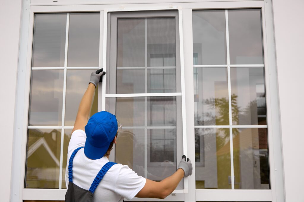 man installing new windows into a home